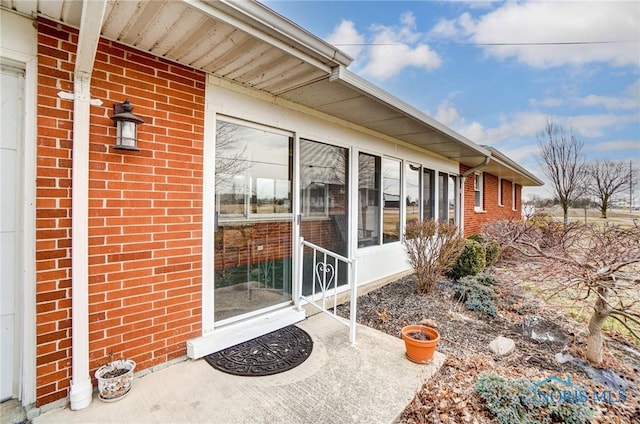 exterior space with a sunroom and brick siding