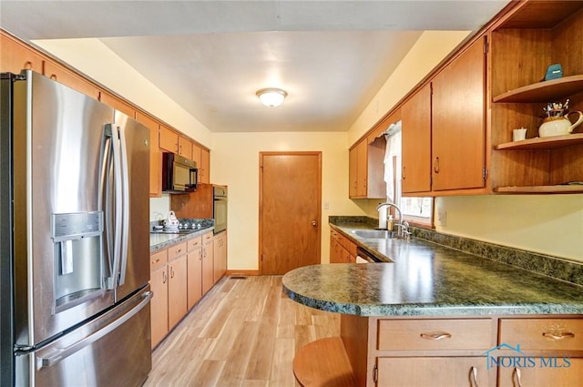 kitchen with open shelves, a sink, light wood-type flooring, black appliances, and dark countertops