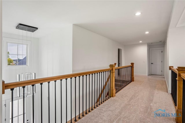 hall with recessed lighting, baseboards, and an upstairs landing