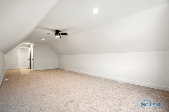 bonus room featuring lofted ceiling, ceiling fan, baseboards, and light colored carpet