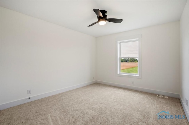 spare room featuring baseboards, visible vents, and light colored carpet