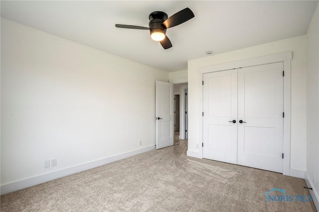 unfurnished bedroom with ceiling fan, baseboards, a closet, and light colored carpet