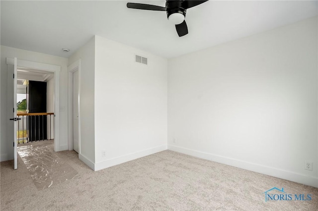 unfurnished room featuring ceiling fan, carpet flooring, visible vents, and baseboards