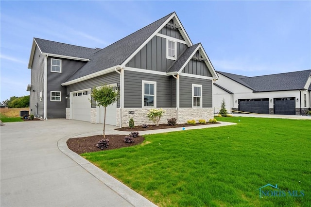 craftsman inspired home featuring board and batten siding, a front yard, a garage, stone siding, and driveway