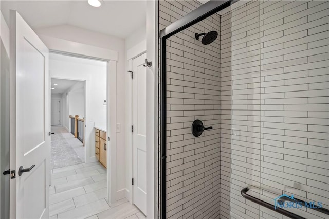 bathroom featuring a stall shower and vaulted ceiling