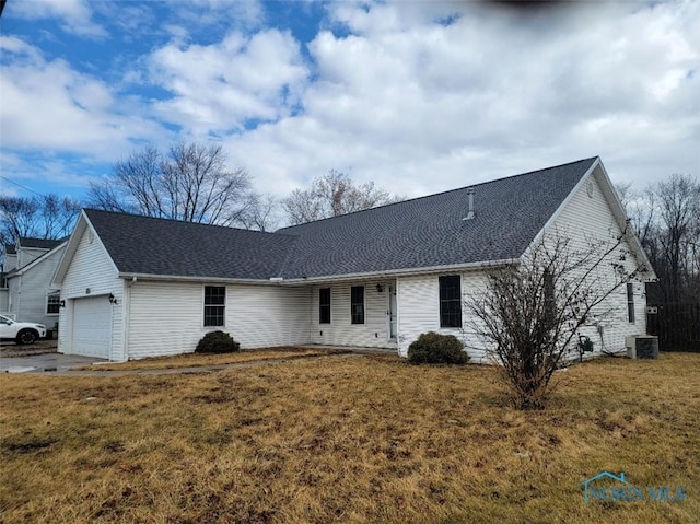 single story home with a shingled roof, a front yard, cooling unit, and an attached garage