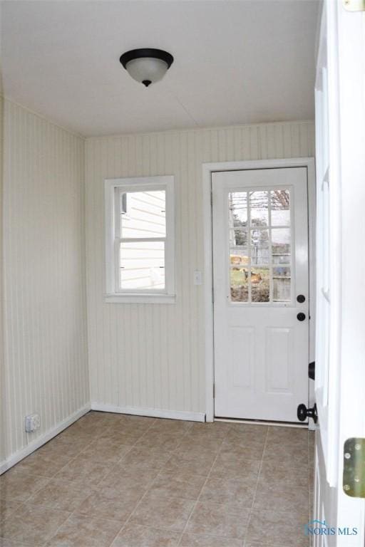 doorway to outside with light tile patterned floors and a healthy amount of sunlight