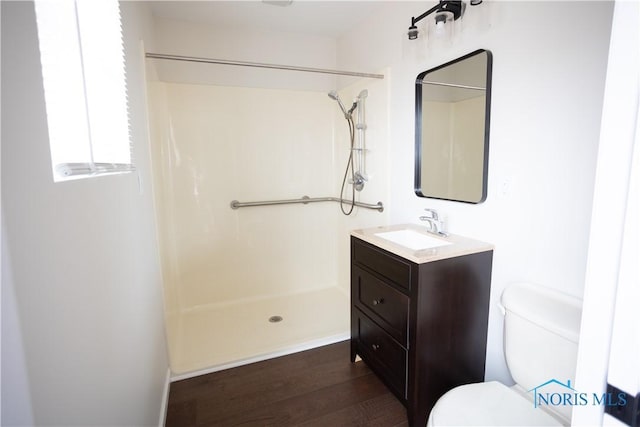 full bathroom with toilet, vanity, walk in shower, and wood finished floors