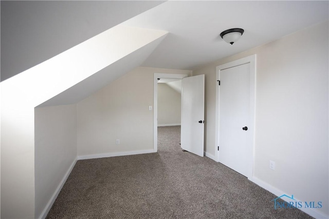 additional living space featuring baseboards, lofted ceiling, and carpet floors