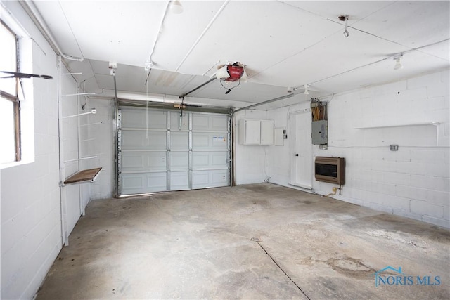 garage with electric panel, concrete block wall, heating unit, and a garage door opener