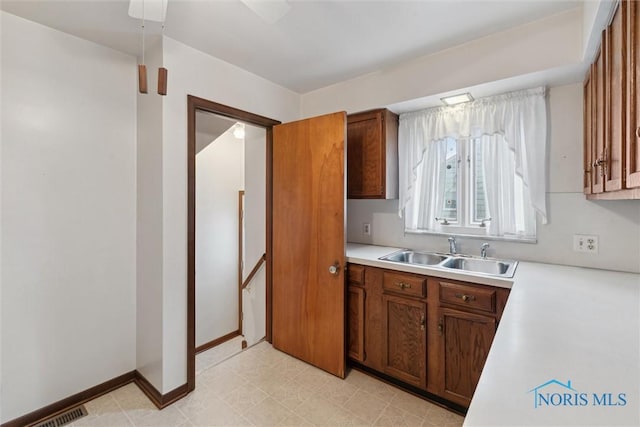 kitchen featuring light floors, visible vents, light countertops, and a sink