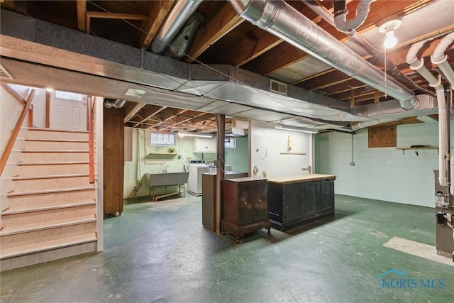 basement with visible vents, independent washer and dryer, stairway, and a sink