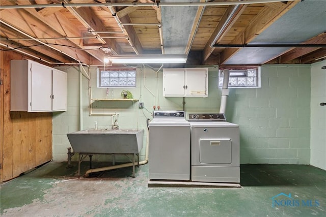 laundry room with separate washer and dryer, a sink, and cabinet space