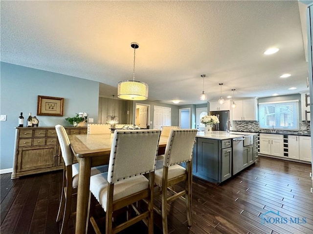 dining room with dark wood-style floors, beverage cooler, a textured ceiling, and recessed lighting