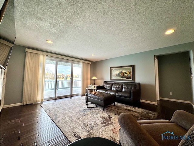 living area with a textured ceiling, baseboards, dark wood-style flooring, and recessed lighting