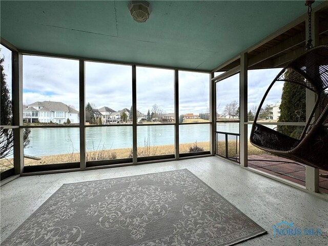 unfurnished sunroom featuring a water view