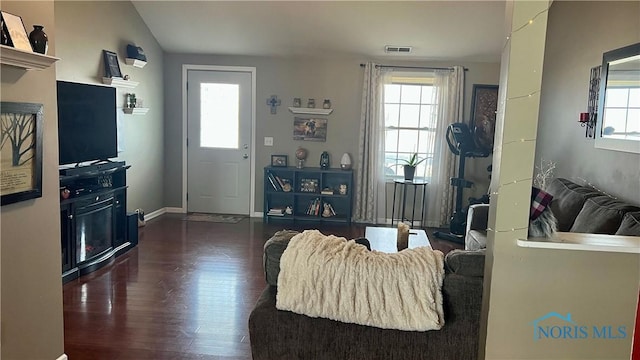 living room with baseboards, visible vents, a wealth of natural light, and wood finished floors