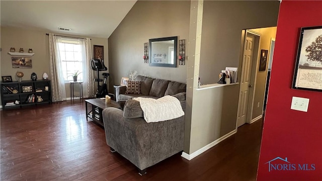 living area with vaulted ceiling, wood finished floors, visible vents, and baseboards