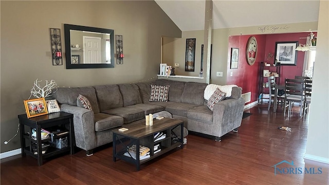 living area featuring baseboards, vaulted ceiling, and wood finished floors