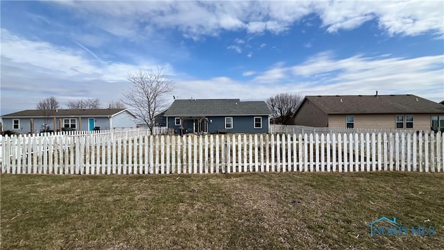 exterior space with a fenced backyard and a front lawn