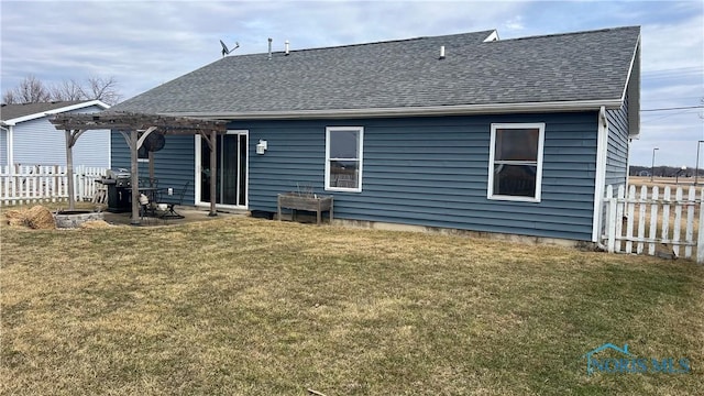 rear view of property featuring a yard, roof with shingles, fence, and a pergola