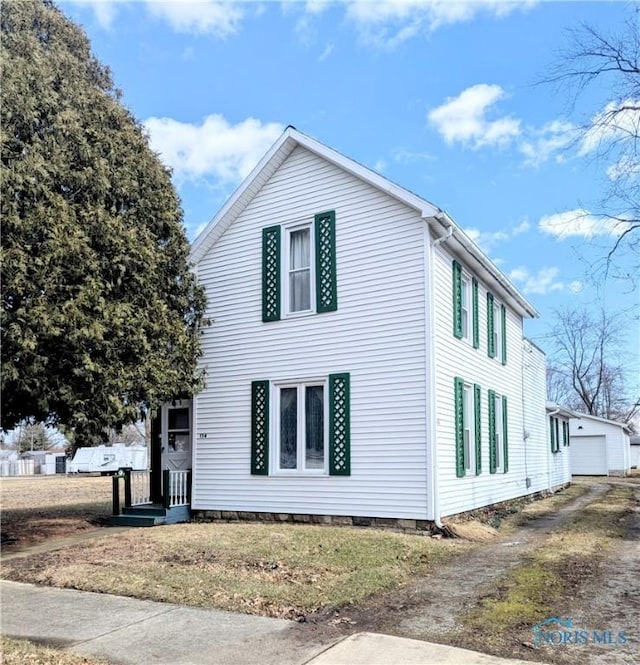 view of property exterior with driveway and an outdoor structure