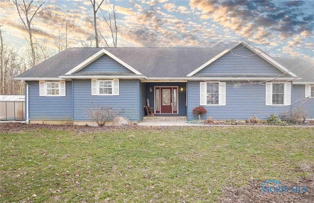 single story home with a shingled roof and a front lawn