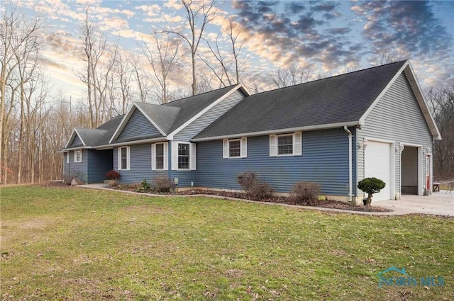 ranch-style house with a shingled roof, a lawn, driveway, and an attached garage