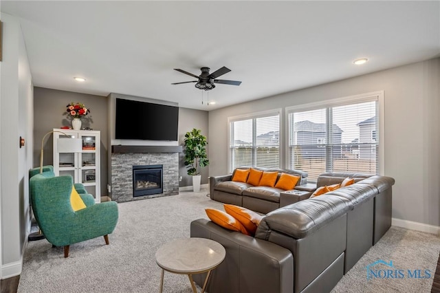 living room featuring baseboards, ceiling fan, a stone fireplace, carpet floors, and recessed lighting