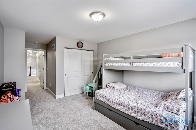 bedroom with a closet, carpet flooring, visible vents, and baseboards