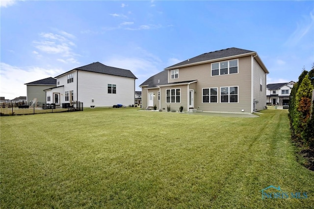 rear view of property with fence and a yard