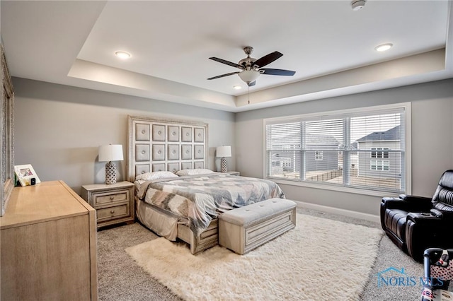 bedroom with light carpet, baseboards, a raised ceiling, ceiling fan, and recessed lighting