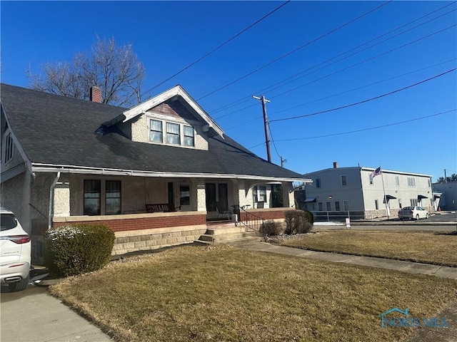 view of front of home with a chimney, a front lawn, and a porch