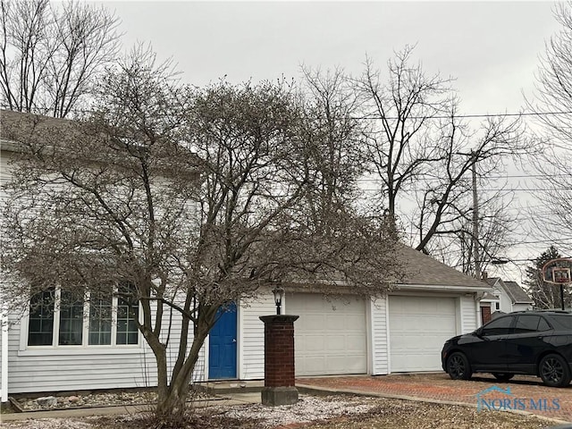 view of property exterior featuring a garage and roof with shingles