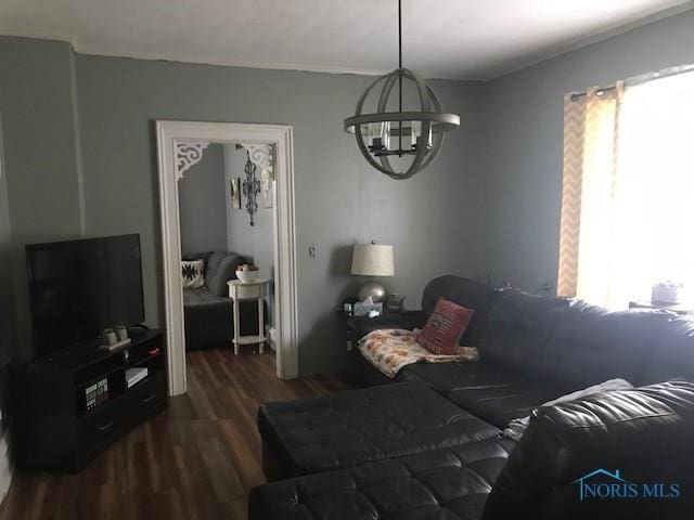 living room with an inviting chandelier, plenty of natural light, and wood finished floors