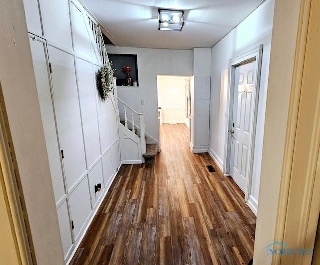 corridor featuring dark wood-style floors and stairway