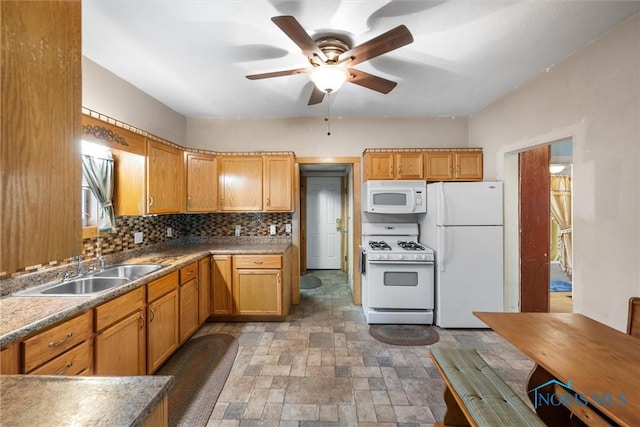 kitchen with tasteful backsplash, a ceiling fan, stone finish floor, a sink, and white appliances