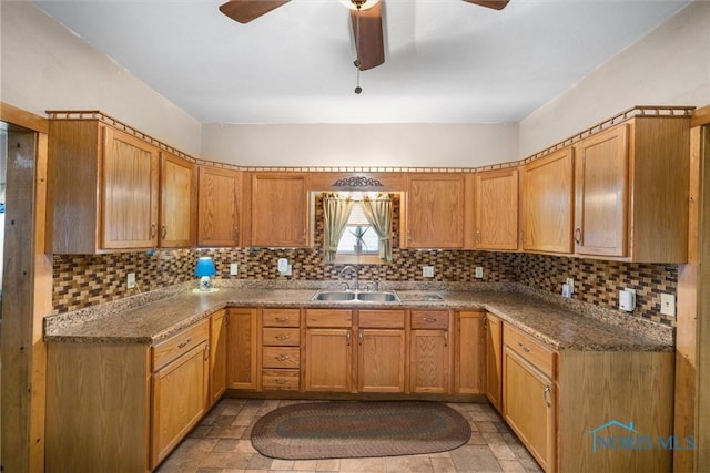 kitchen with ceiling fan, stone finish flooring, tasteful backsplash, and a sink