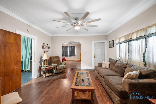 living room with a ceiling fan, arched walkways, ornamental molding, and wood finished floors