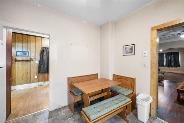 dining area with wood walls and stone finish floor