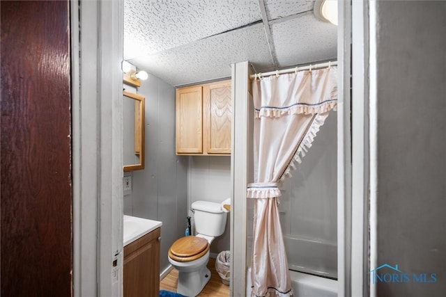 bathroom featuring a paneled ceiling, vanity, toilet, and curtained shower