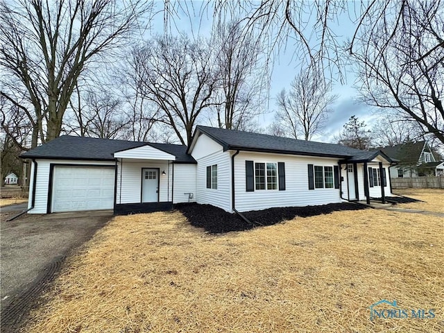 single story home with a garage, driveway, and a front lawn