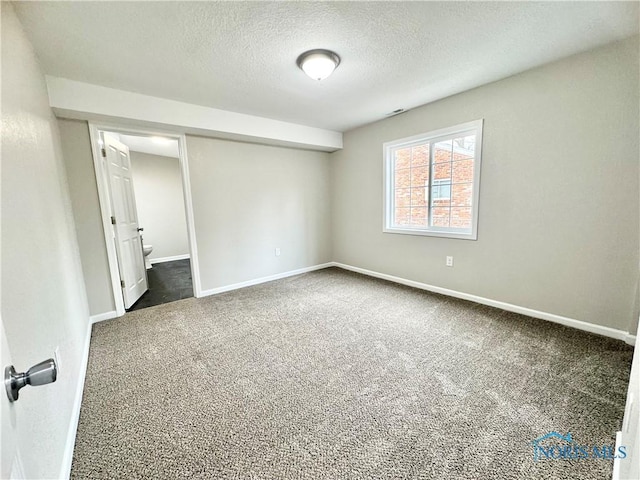 unfurnished bedroom featuring carpet, baseboards, and a textured ceiling