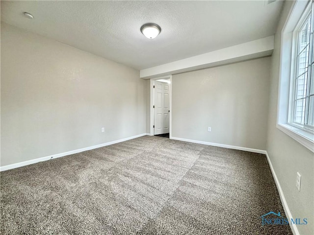 empty room featuring carpet floors, baseboards, and a textured ceiling