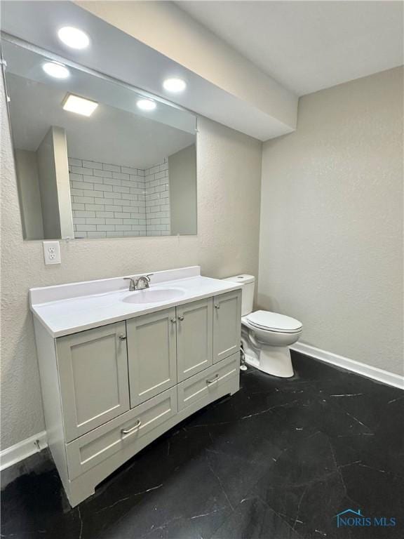 bathroom featuring recessed lighting, a textured wall, toilet, vanity, and baseboards