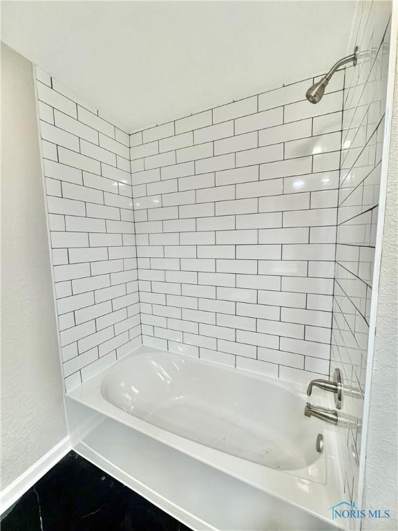 full bathroom with baseboards and tub / shower combination