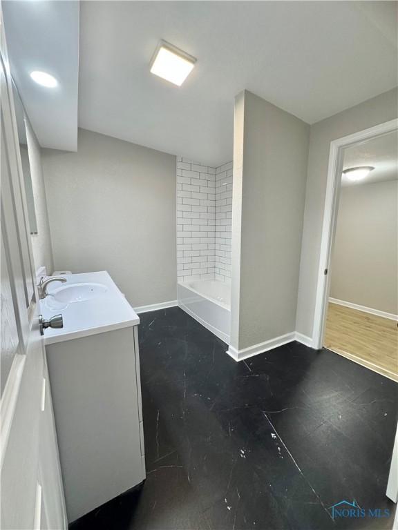 full bath with baseboards and vanity