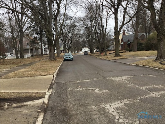 view of road featuring curbs, sidewalks, and a residential view