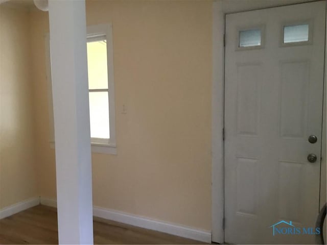 interior space featuring baseboards and wood finished floors