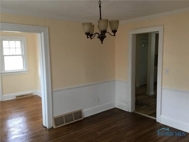 unfurnished dining area with dark wood-type flooring, visible vents, and ornamental molding